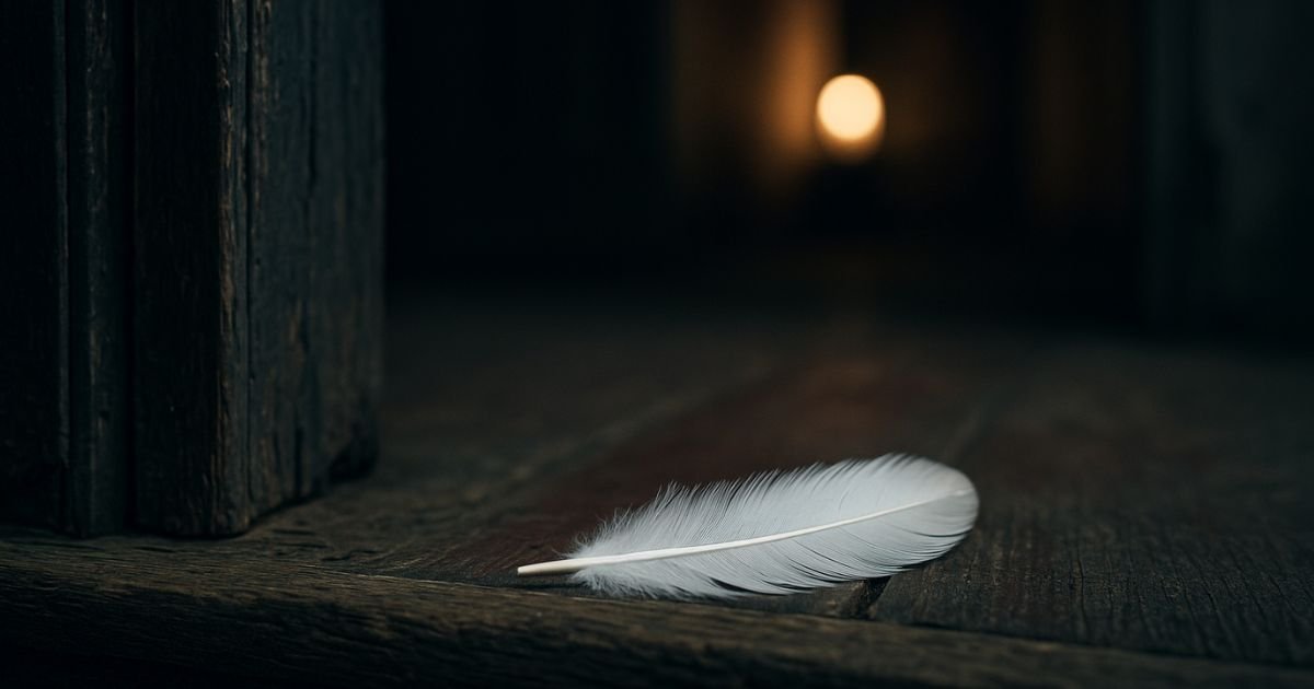Une plume blanche posée sur un vieux seuil en bois, éclairée par une lumière douce au loin, symbole d’un signe venu d’un proche disparu.