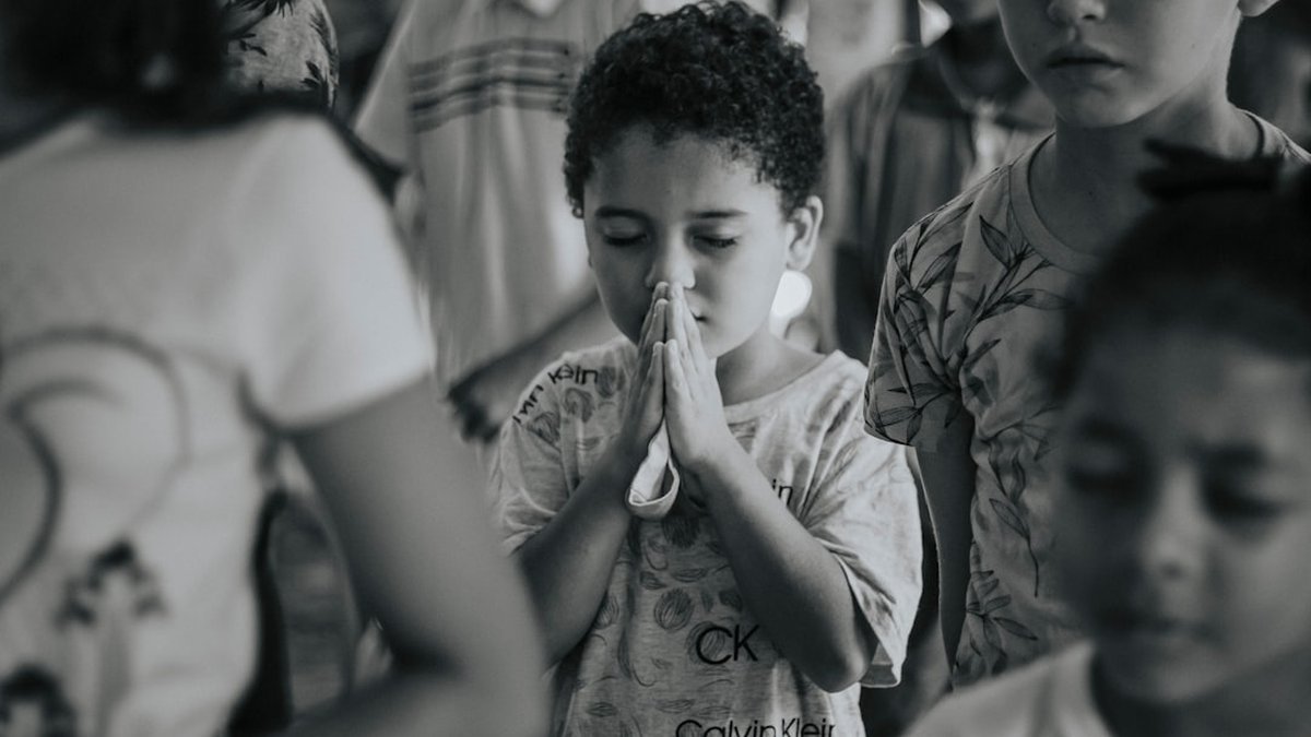 Un enfant qui prie les mains jointes, photo en noir et blanc